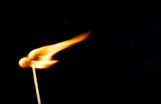 Wooden match with a sulfur head at the moment when it explodes.