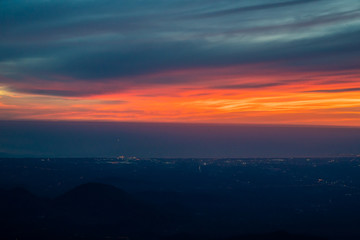 Twilight to Night from the jet plane view red orange blue sky with the light of Thailand city below