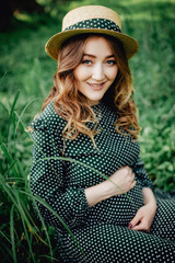 Pregnant woman posing in a green park. young happy pregnant woman relaxing and enjoying life