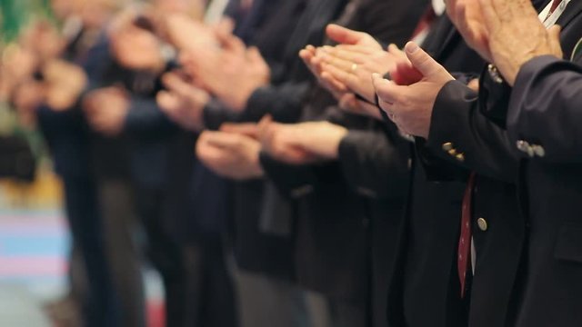 Business people standing in the row at the conference and clapping their hands - applause