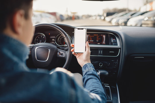 Handsome man using mobile phone while driving. - Powered by Adobe