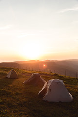 Camping tent in Mountains Morning sunrise orange Landscape Travel Lifestyle concept adventure vacations outdoor hiking gear equipment