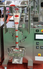 Snack package filling and sealing machine. Food industry