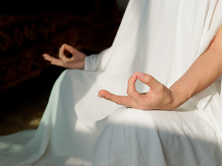 Close up Hand Gesture of Woman in white robe Doing Lotus Yoga Position, an Activity to Stay...