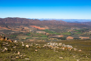 Fototapeta na wymiar Looking down on green farm land from the Swartberg Pass