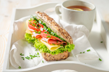 Tasty sandwich with ham, chive and cheese for breakfast