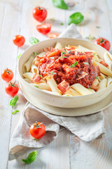 Delicious penne bolognese made of fresh tomatoes and hebrs