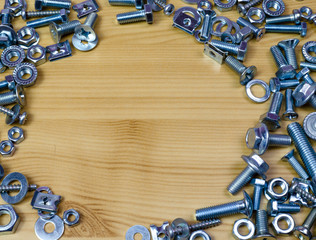 set of bolts and nuts on a wooden background