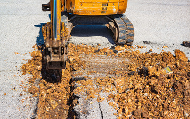 mini excavator equipped with a very narrow bucket to perform excavations of small width in the...