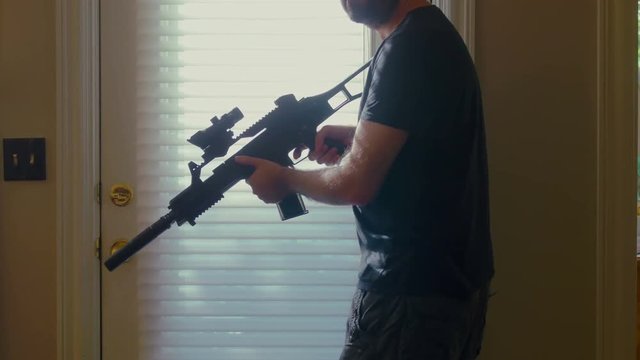 Man nervously walking around house with a rifle