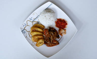 African fried chicken with fried bananas, rice, fried onions, chili sauce and candlenut sauce.
