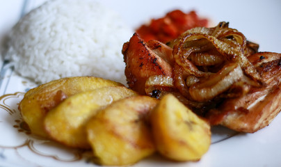 African fried chicken with fried bananas, rice, fried onions, chili sauce and candlenut sauce.