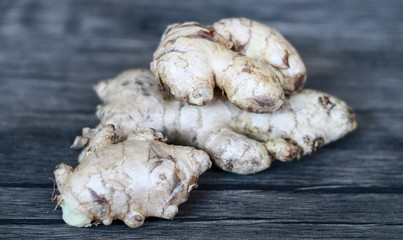 Ginger or Zingiber officinale on wood background. Used as a spice and a folk medicine.