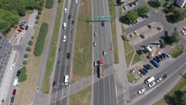 Aerial view of the busy highway of the city of Warsaw. Traffic passing by a highway. Top view of highway and overpass in city on a sunny day. Shot on Drone 4K.