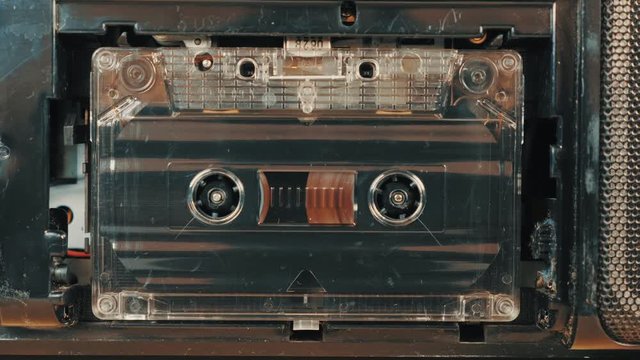 Vintage music audio player. Movement of reels with magnetic tape in an old audio cassette. Closeup. Dolly shot.