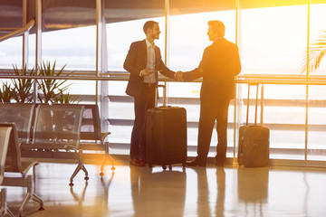 Business people give handshake at the airport
