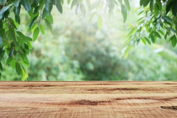 Wooden table and blurred green leaf nature in garden background. 