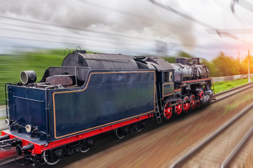 Vintage black steam locomotive train fast rush railway, back view.