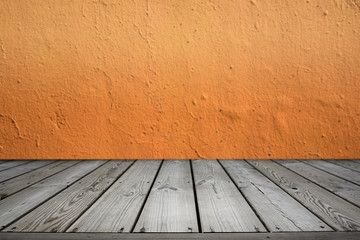 Wooden table and texture of orange color cement wall background.