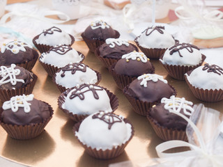Many delicious cupcakes are on the table.