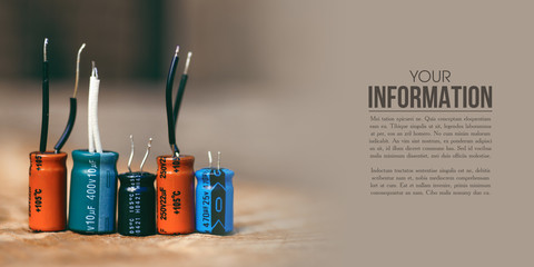 electrolytic capacitor electronic detal on wooden background - obrazy, fototapety, plakaty