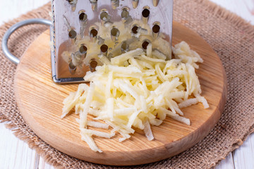 Grated apple on a cutting board on wooden table