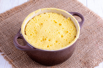 Dough in ceramic form. Cooking cupcake in the microwave