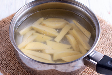 Cut potatoes in a saucepan with starting water to boil. Potato slices in pan with water