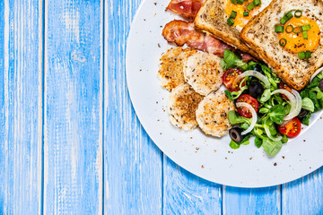 Breakfast - toasted bread with fried egg, bacon and vegetables