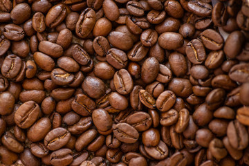 roasted brown coffee beans scattered close-up, background, texture