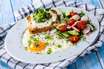Breakfast - fried egg, toasts and vegetable salad