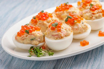 Stuffed eggs with red caviar.