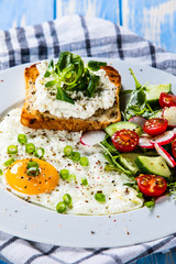 Breakfast - fried egg, toasts and vegetable salad