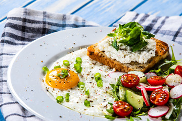 Breakfast - fried egg, toasts and vegetable salad