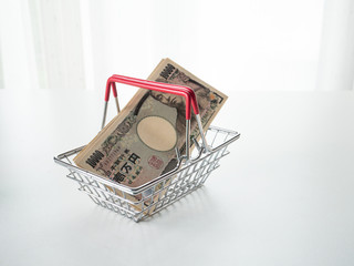Japanese Yen in shopping basket on white background