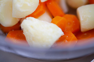 茹でたジャガイモとニンジンにマヨネーズをかける