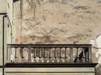 Old concrete balustrade in Art Noveau style. Weathered  scratched paint wall behind. Background for copy space