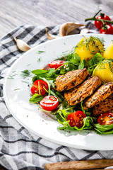 Grilled chicken fillet and vegetables on white plate