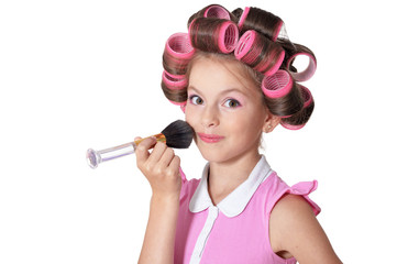 Portrait of little pretty girl with hair curlers with brush