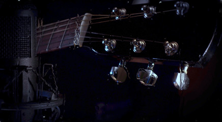 musician playing guitar at studio behind the glass with water drops
