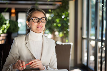 Happy young blonde woman in glasses working in a restaurant
