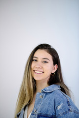 Young caucasian girl with brown hair posing on grey background