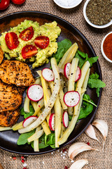 Grilled chicken fillet and vegetables on wooden table