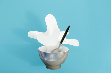 Creative food diet healthy food concept photo milk splatter in plate with spoon on blue background