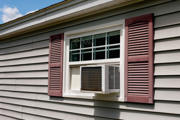 Air conditioner in house window on Summer day.