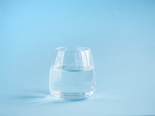 a glass of plain water on a blue background