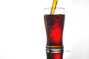pouring cola into glass with ice on white background Copy space