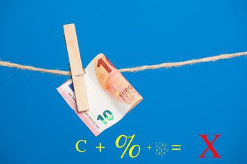 Billetes de Euro sobre fondo azul, colgados de una cuerda y sujetos por pinzas de extender la ropa....