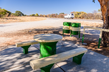 Concrete picnic table and benches placed beside a tree for shade, typically placed every 10-20kms along roads in Namibia