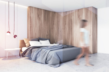 Woman walking in white and wooden bedroom